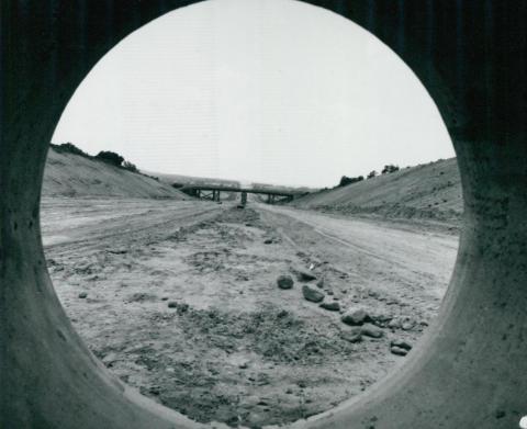 Az M3-as autópálya épülő felüljárója, vasbeton közműcső mögül fotózva